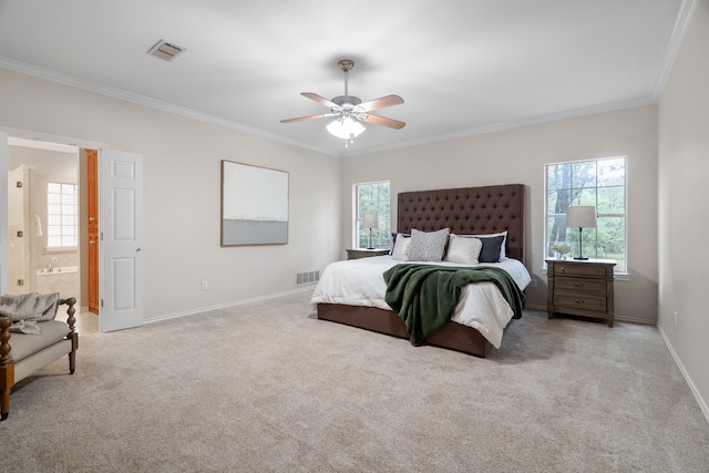 carpeted bedroom featuring ceiling fan, ornamental molding, multiple windows, and ensuite bath