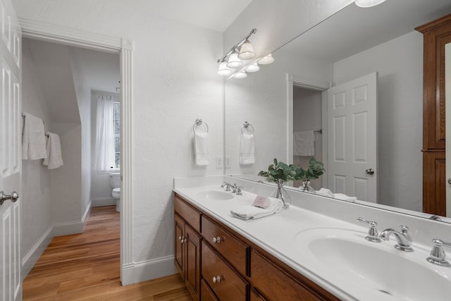 bathroom with hardwood / wood-style flooring, vanity, and toilet