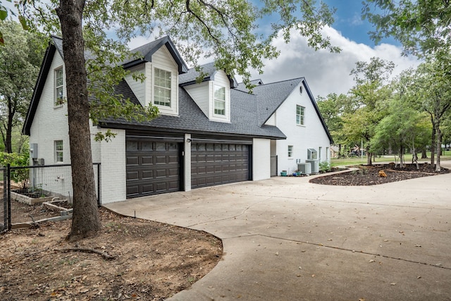 view of side of home with central AC unit and a garage