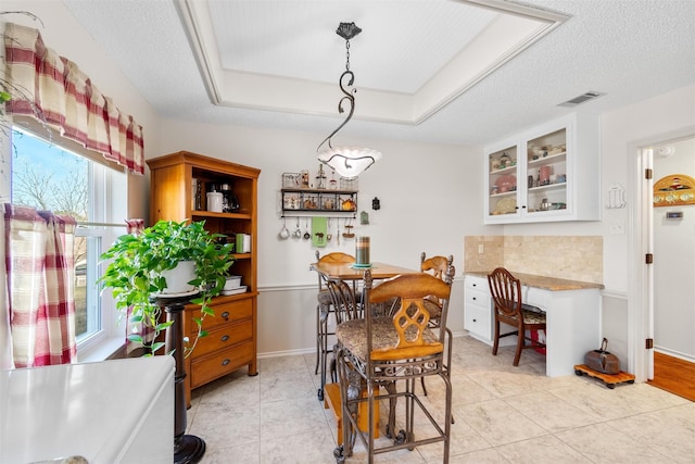 tiled dining room featuring a textured ceiling