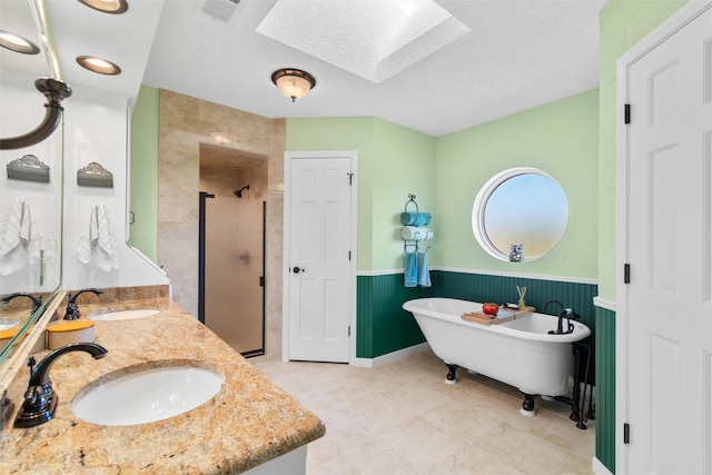 bathroom with vanity, plus walk in shower, a skylight, and a textured ceiling