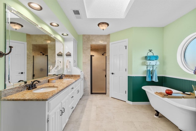 bathroom featuring vanity, a skylight, independent shower and bath, and a textured ceiling