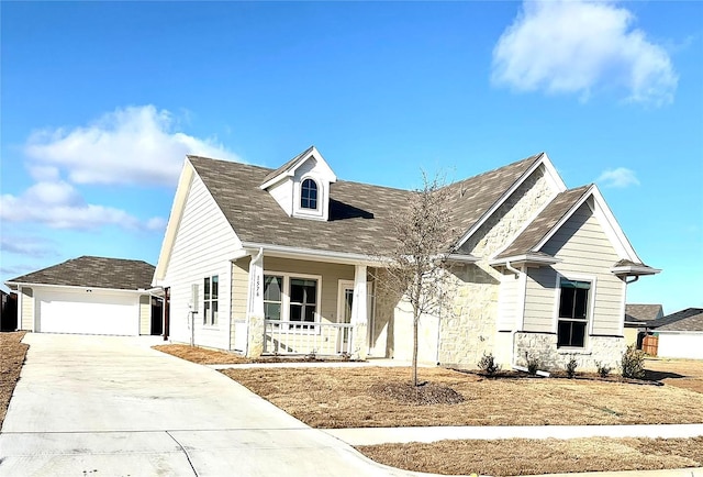 view of front facade featuring a porch, a garage, and an outdoor structure