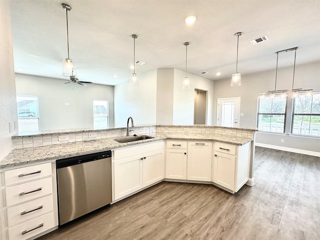 kitchen featuring sink, white cabinets, ceiling fan, stainless steel dishwasher, and light stone countertops