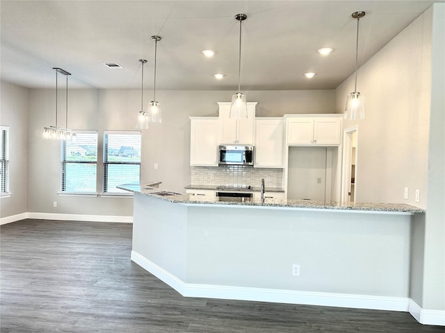 kitchen featuring light stone counters, dark hardwood / wood-style floors, decorative light fixtures, tasteful backsplash, and white cabinets