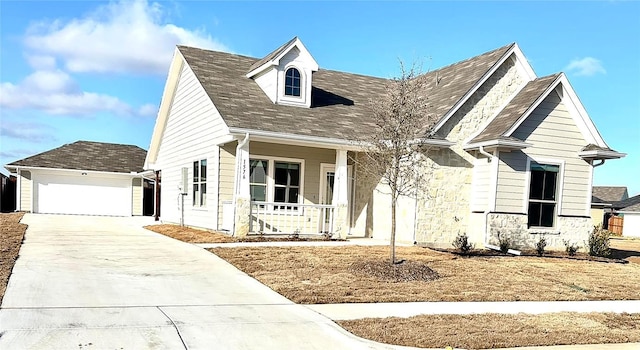 view of front of home with a garage, a porch, and an outdoor structure