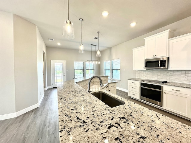 kitchen with sink, decorative light fixtures, white cabinetry, and appliances with stainless steel finishes