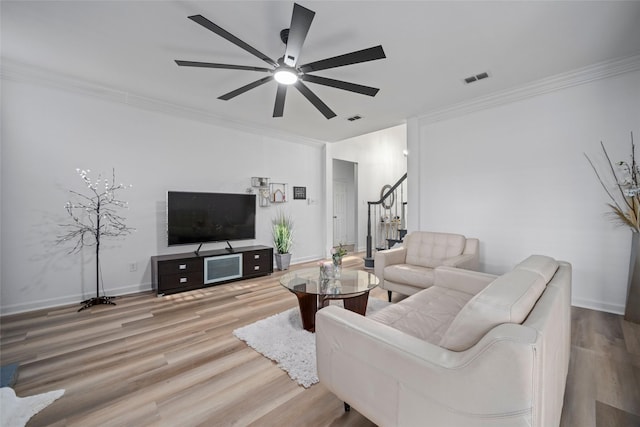 living room with wood-type flooring, ceiling fan, and ornamental molding