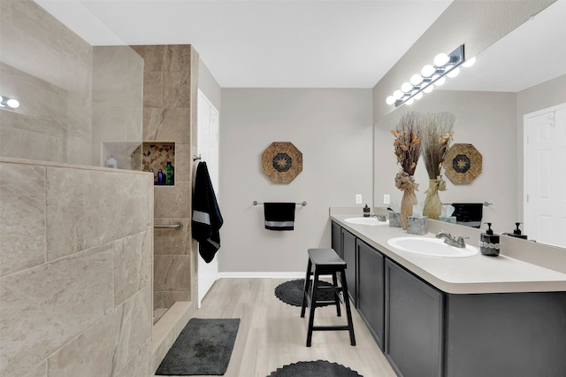 bathroom featuring a tile shower, hardwood / wood-style floors, and vanity