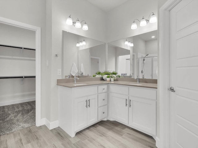 bathroom with vanity, wood-type flooring, and walk in shower