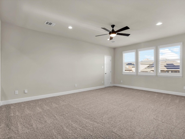 carpeted spare room featuring ceiling fan