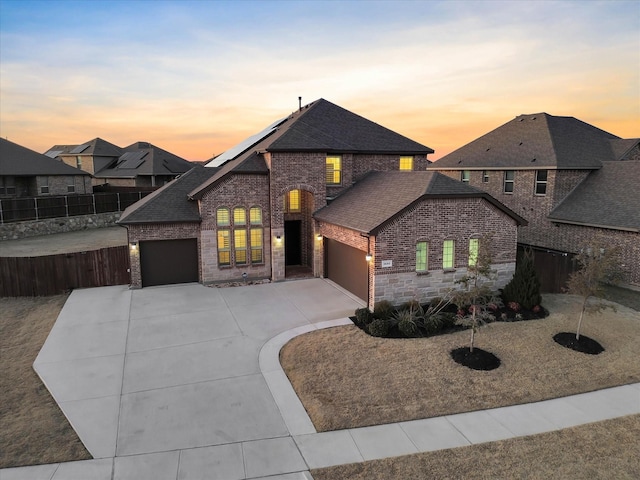 view of front of home featuring solar panels and a garage