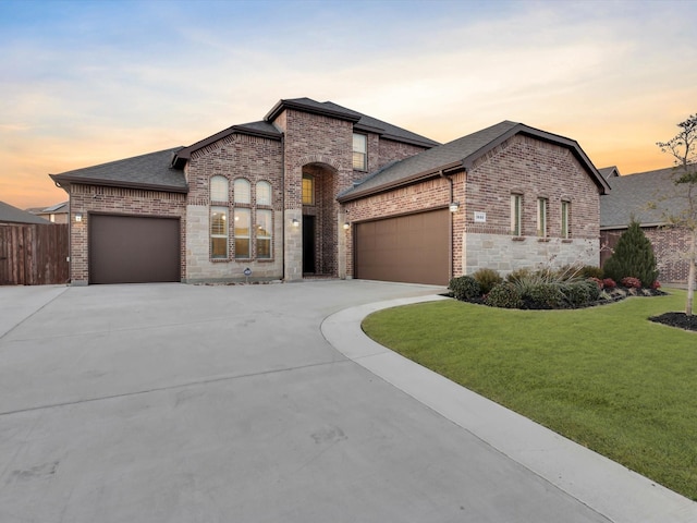 french country style house with a garage and a lawn