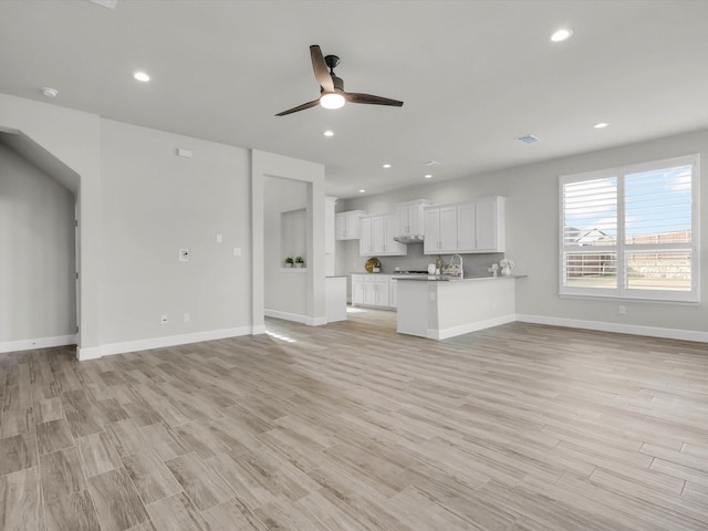 unfurnished living room with ceiling fan and light hardwood / wood-style floors