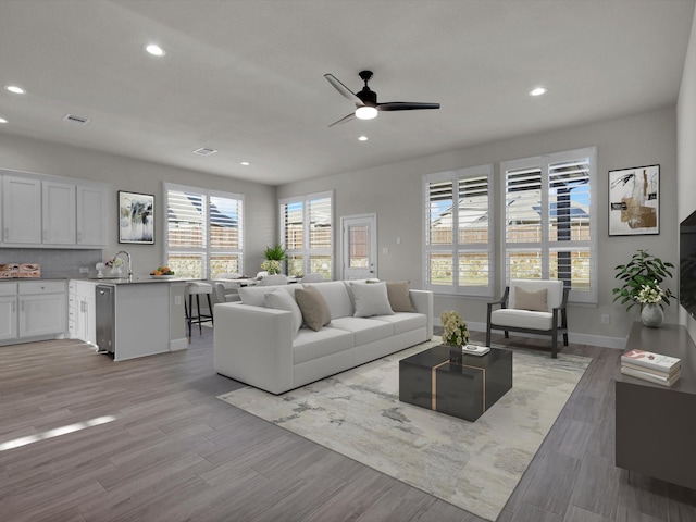 living room featuring ceiling fan and sink