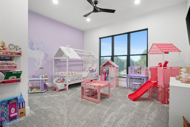 bedroom with ceiling fan, carpet floors, and a nursery area