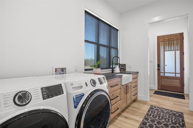 washroom featuring sink, cabinets, light wood-type flooring, and independent washer and dryer