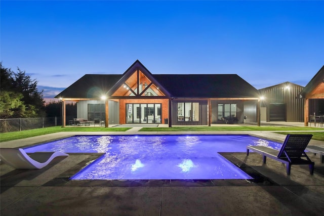 pool at dusk with a patio area