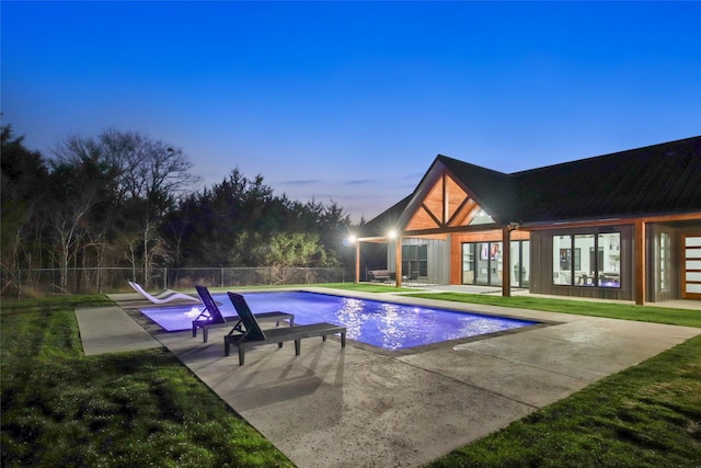 pool at dusk featuring a patio