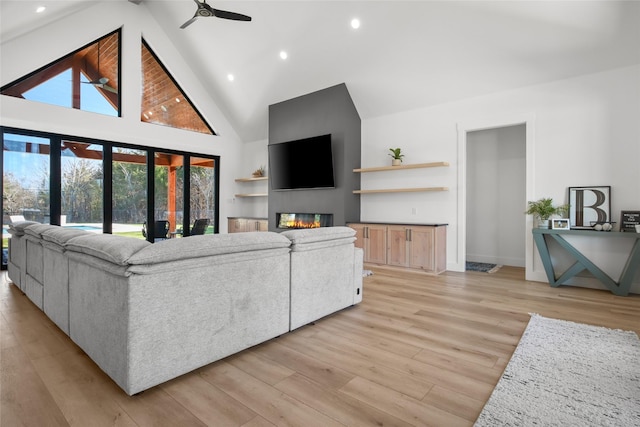 living room featuring ceiling fan, light hardwood / wood-style flooring, and high vaulted ceiling