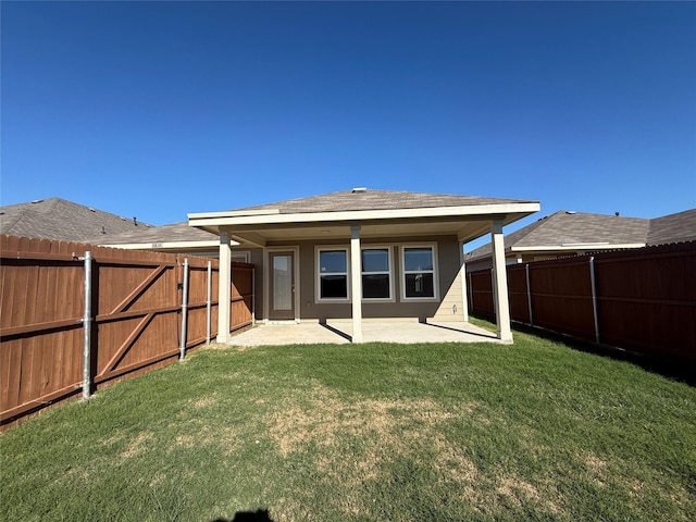 rear view of property featuring a lawn and a patio