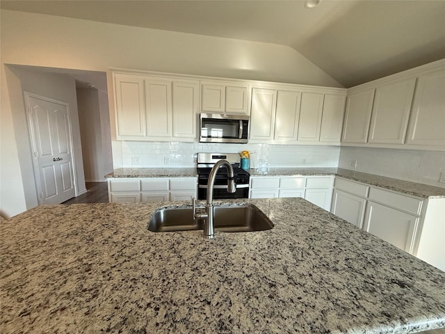 kitchen featuring sink, stainless steel appliances, tasteful backsplash, a kitchen island with sink, and white cabinets