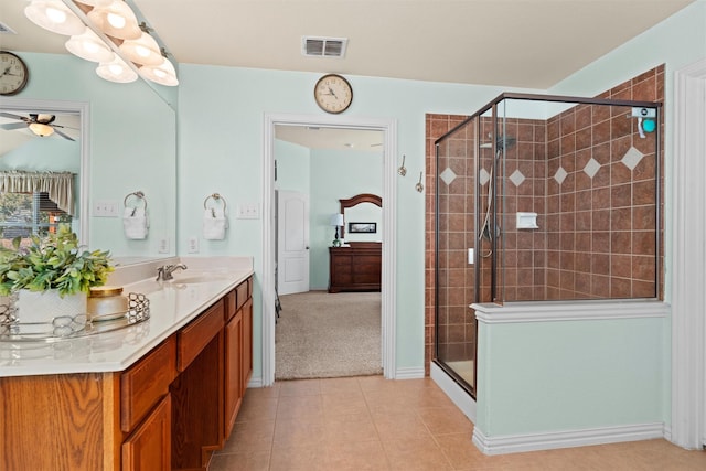 bathroom with ceiling fan, tile patterned flooring, vanity, and a shower with shower door