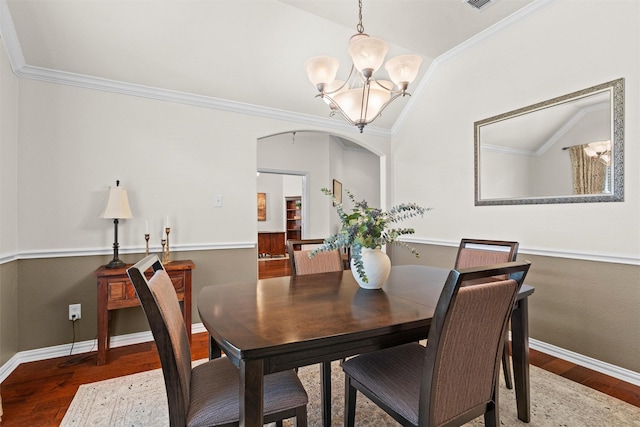 dining room featuring wood-type flooring, ornamental molding, and a chandelier