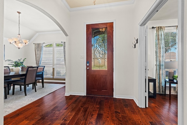 foyer entrance with a chandelier, dark hardwood / wood-style flooring, vaulted ceiling, and a wealth of natural light