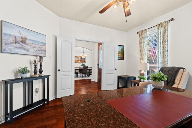 dining room with ceiling fan with notable chandelier and dark hardwood / wood-style floors