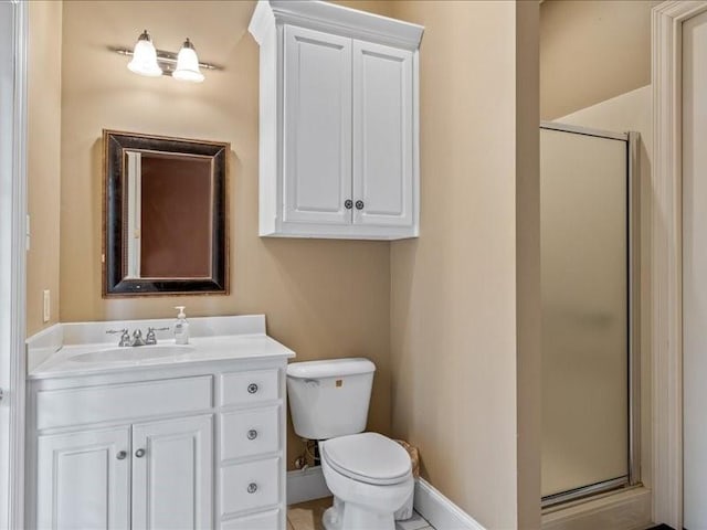 bathroom featuring toilet, vanity, and a shower with shower door