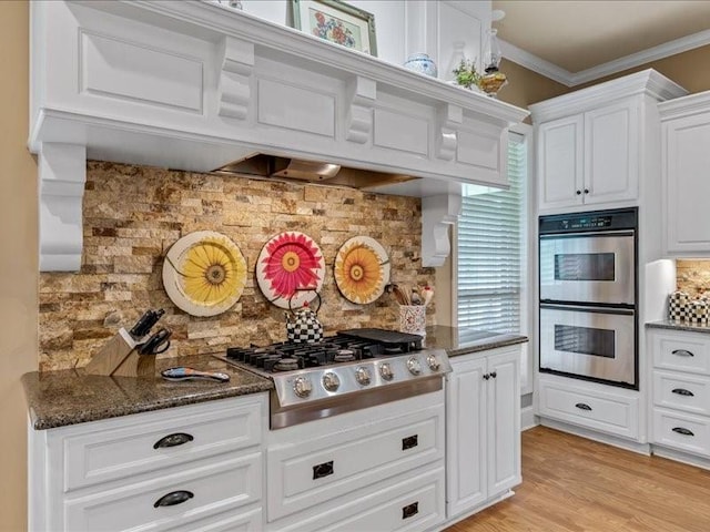 kitchen with crown molding, stainless steel appliances, white cabinets, and decorative backsplash