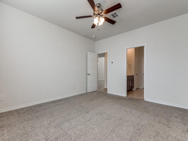 unfurnished bedroom featuring connected bathroom, light colored carpet, and ceiling fan