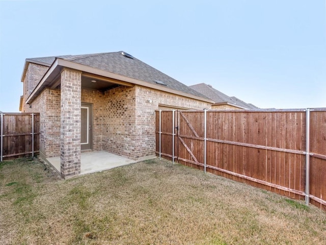 rear view of house featuring a yard and a patio