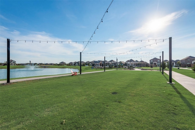 view of property's community with a lawn and a water view