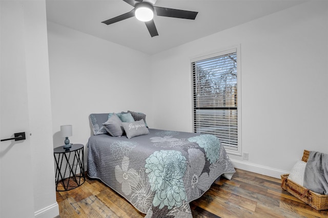 bedroom with a ceiling fan, hardwood / wood-style flooring, and baseboards