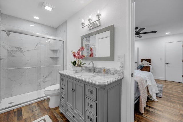 ensuite bathroom featuring toilet, a stall shower, connected bathroom, vanity, and wood finished floors