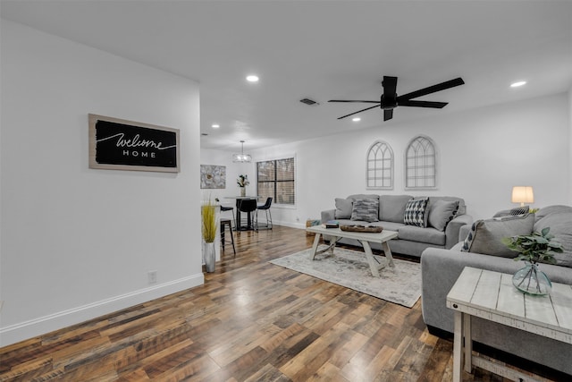 living area with recessed lighting, baseboards, visible vents, dark wood-type flooring, and ceiling fan with notable chandelier