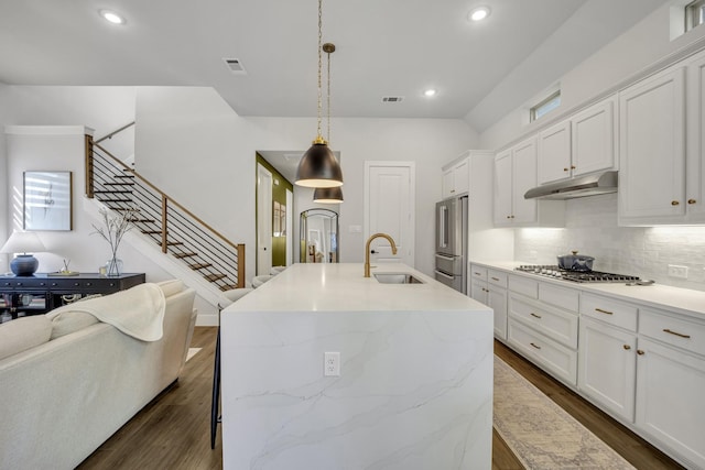 kitchen with pendant lighting, an island with sink, stainless steel appliances, white cabinets, and sink