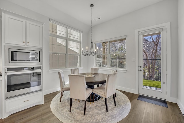 dining room featuring dark hardwood / wood-style flooring and a chandelier