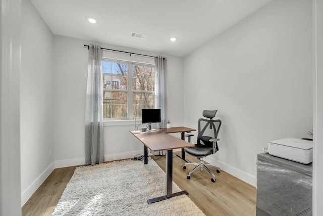 home office with light hardwood / wood-style flooring