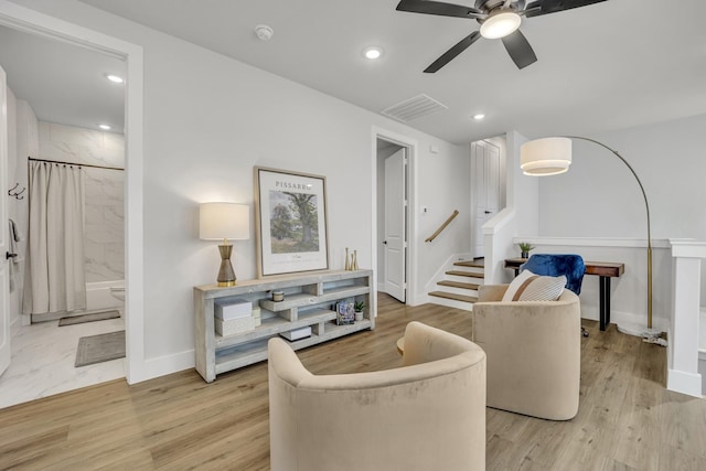 living room featuring light wood-type flooring and ceiling fan