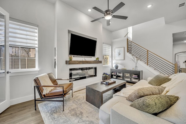 living room featuring light wood-type flooring and ceiling fan