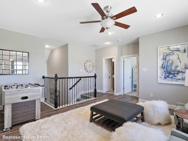 living area with ceiling fan and dark hardwood / wood-style flooring