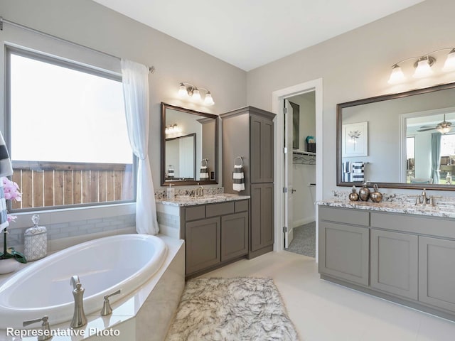 bathroom featuring vanity and tiled bath