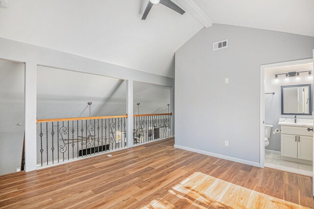 interior space with ceiling fan, lofted ceiling with beams, light hardwood / wood-style floors, and sink