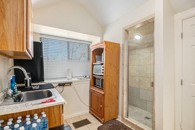 kitchen featuring sink, vaulted ceiling, and light tile patterned flooring