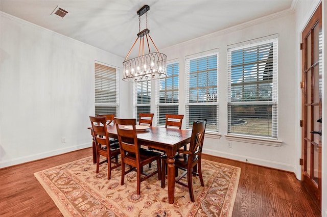 dining room featuring crown molding, a chandelier, and hardwood / wood-style floors