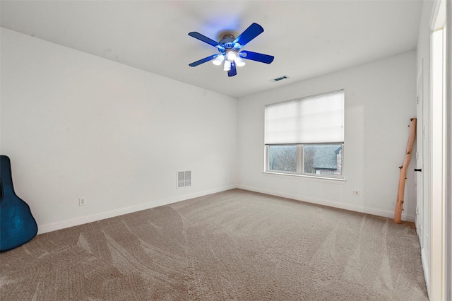 carpeted spare room with ceiling fan