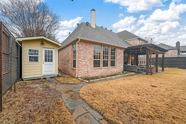 rear view of house with a storage shed, a pergola, and a lawn